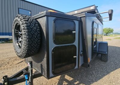 Exterior view of the CORE RV 5510 front insulated storage box with 2 lockable compartments and front spare mounted tire