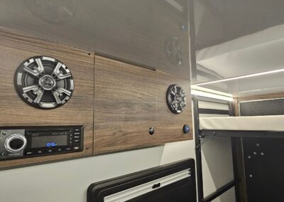 Interior view of the CORE 6515 Trailhead upper entertainment cabinet with radio and speakers